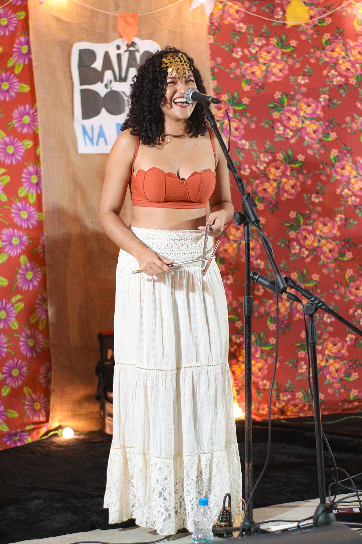 Cantora com triângulo no palco do Baião na Praça