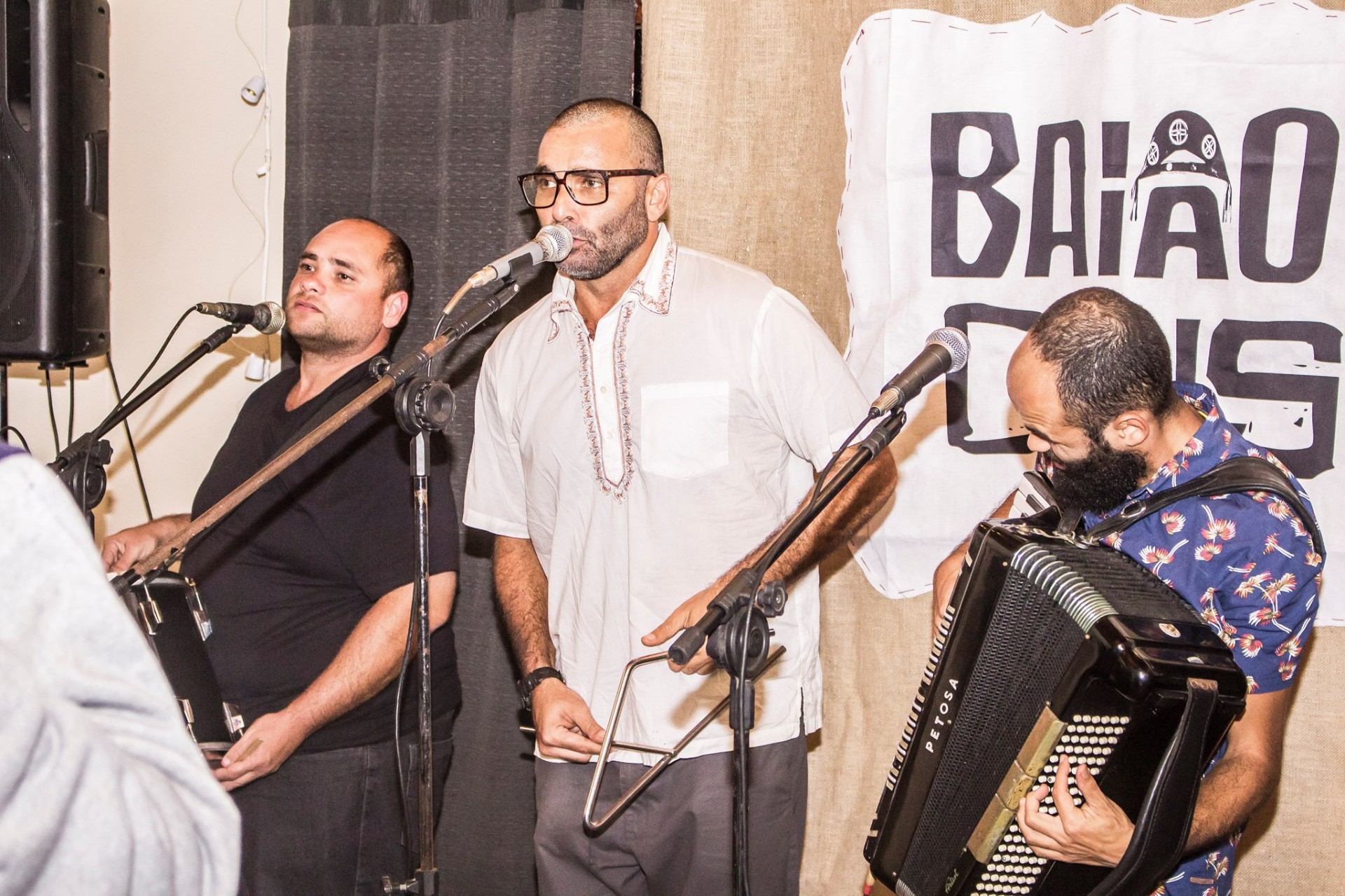 Cantadores e sanfoneiro no microfone